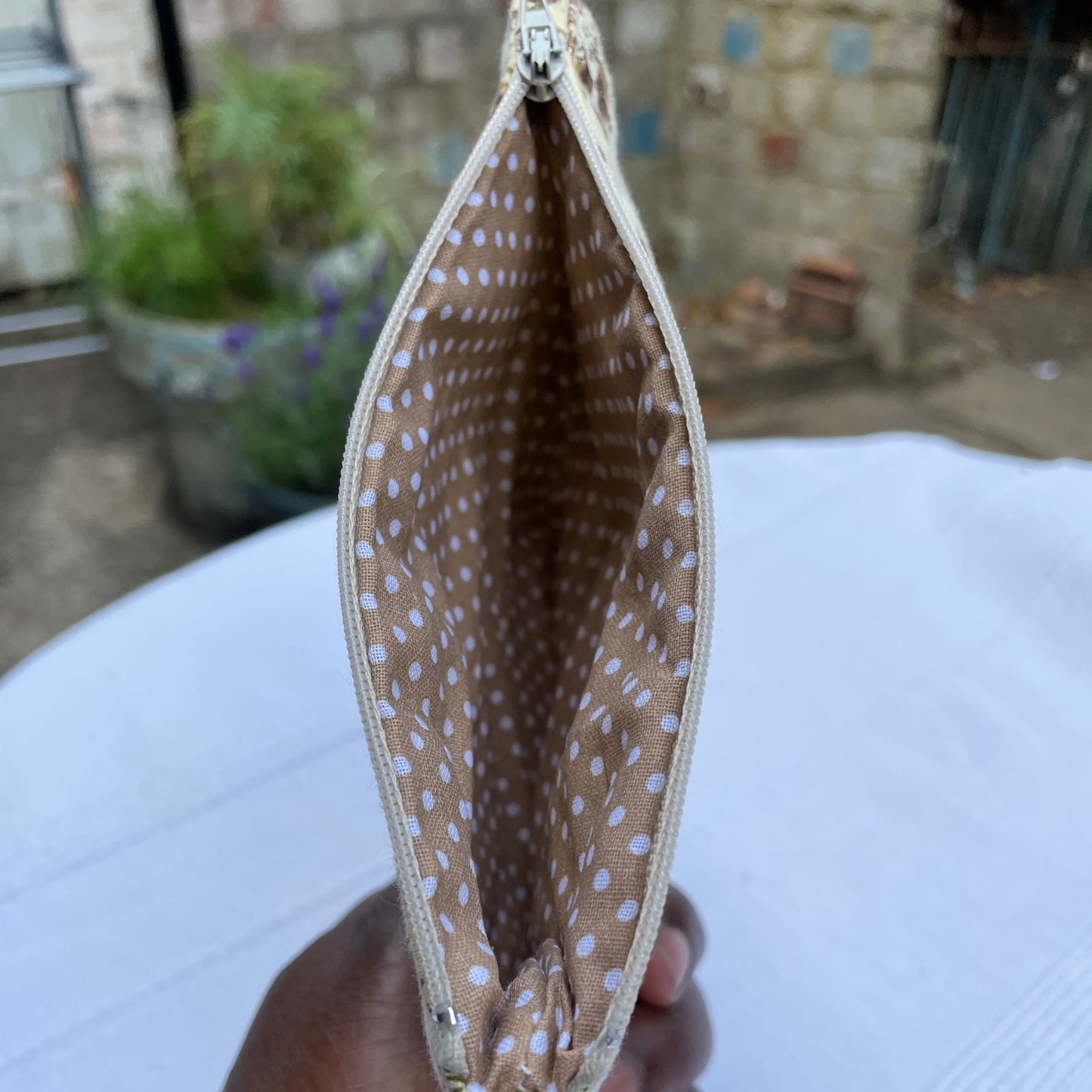 Beige Floral pattern with a polka dot lining pouch with a blurred background