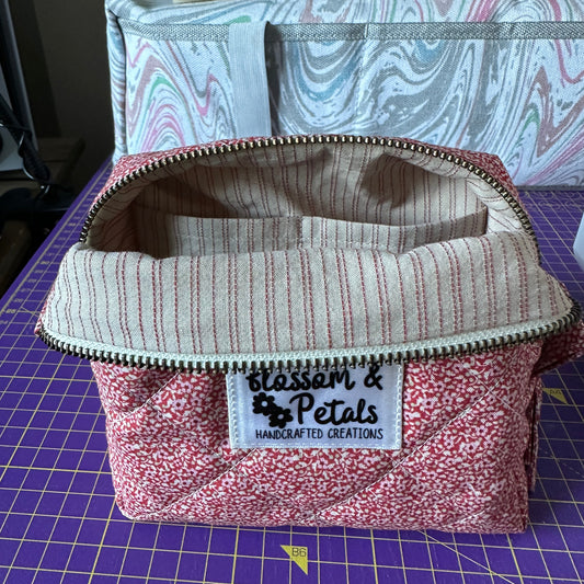 Handmade red floral quilted makeup bag with zip closure, cotton cosmetic pouch featuring a classic floral pattern, perfect for everyday makeup and travel use.