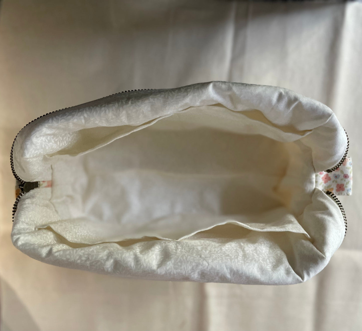 Open white pouch with floral pattern on a light background