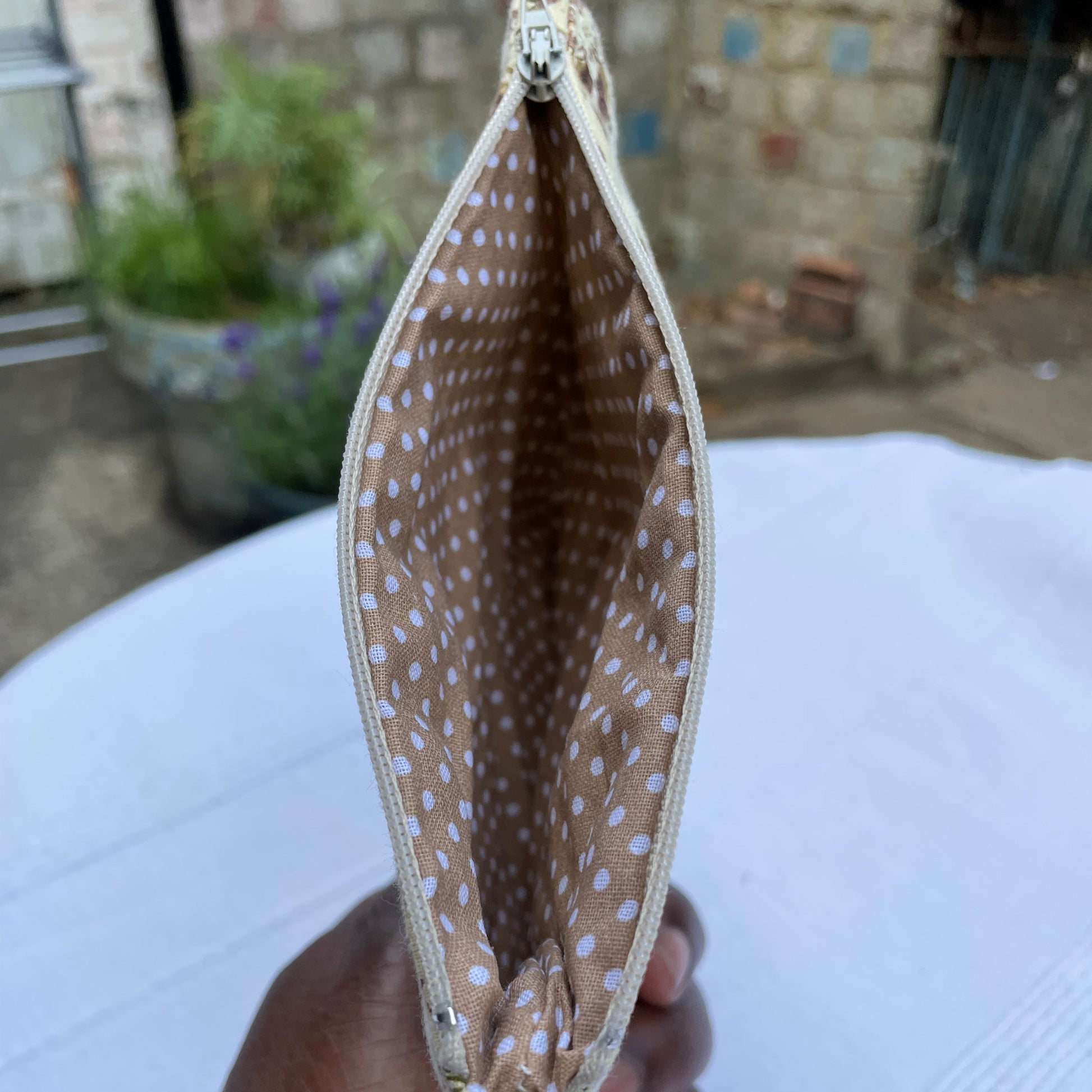 Beige Floral pattern with a polka dot lining pouch with a blurred background