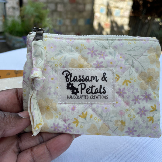 Floral-patterned product with 'Blossom & Petals' label held by a hand against a blurred outdoor background.