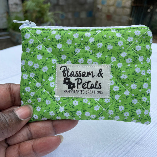 Green floral fabric pouch held by a hand with 'Blossom & Petals' label.