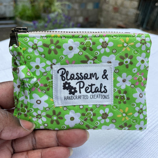 Green floral patterned pouch held by a hand with 'Blossom & Petals' label.