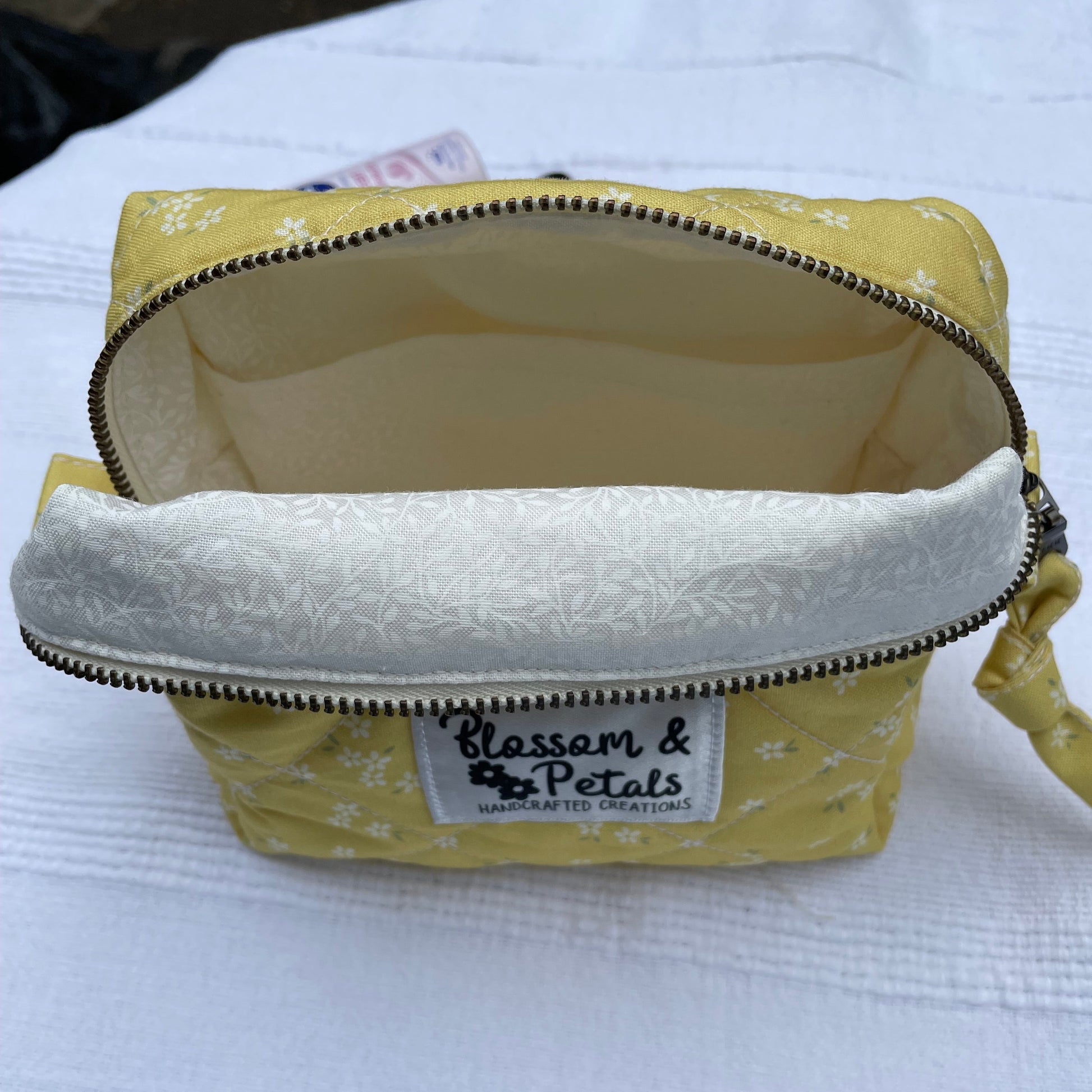 Yellow pouch with a zipper and visible brand label on a white background