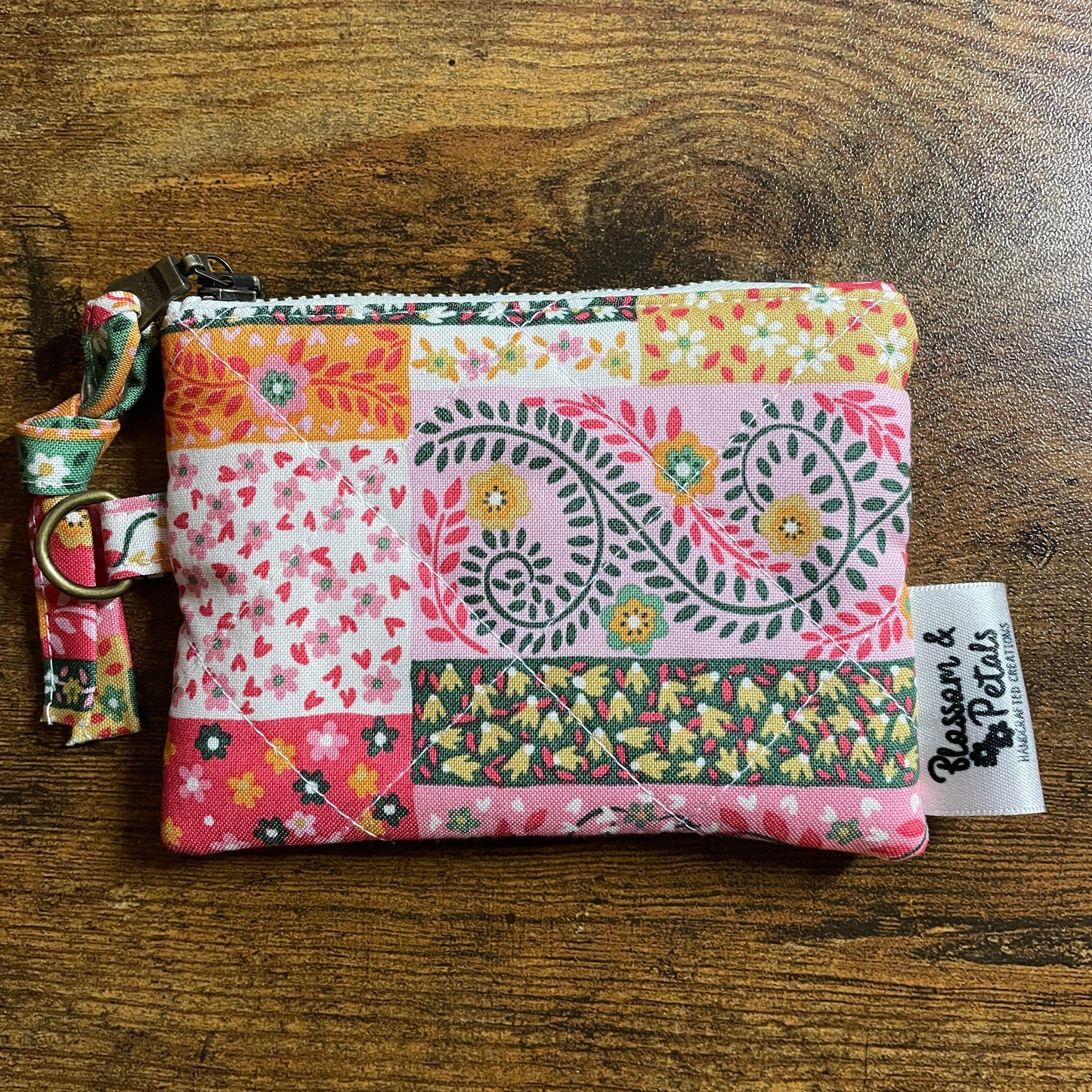 Small quilted floral patchwork pouch with zipper, handmade from colourful cotton fabric, ideal for coins, cards and everyday essentials.