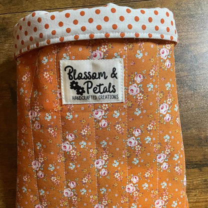 Handmade quilted book sleeve in rust floral cotton fabric with padded design to protect books, journals, planners, and e-readers.