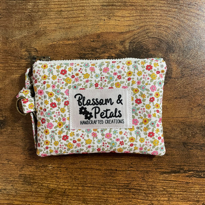 Handmade floral quilted zipper pouch in cotton fabric with branded label, ideal as a coin purse, small makeup bag, or everyday accessory pouch