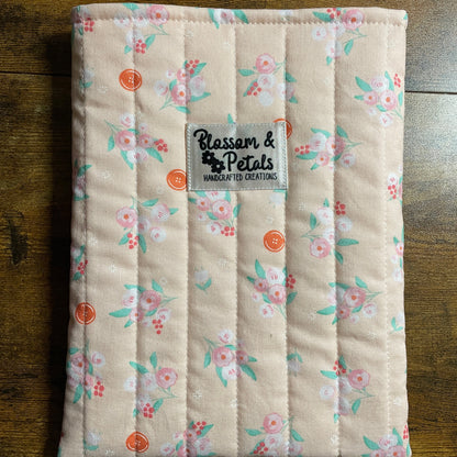 Handmade quilted peach floral book sleeve with soft cotton fabric and Blossom & Petals label, padded book cover for books, journals, and planners.
