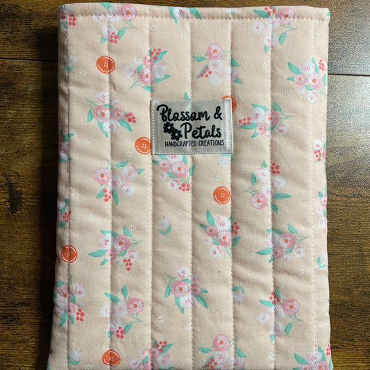 Handmade quilted peach floral book sleeve with soft cotton fabric and Blossom & Petals label, padded book cover for books, journals, and planners.