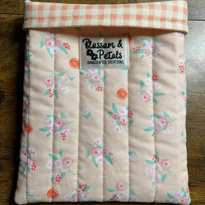 Handmade quilted peach floral book sleeve with soft cotton fabric and Blossom & Petals label, padded book cover for books, journals, and planners.