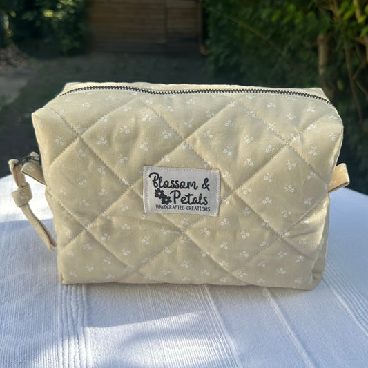 Handmade beige quilted medium makeup bag with zipper, featuring a neutral minimalist design for storing cosmetics or toiletries