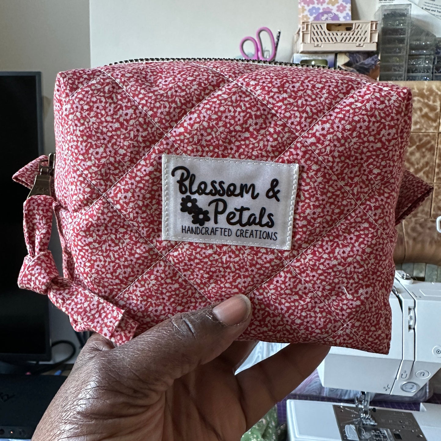 Handmade red floral quilted makeup bag with zip closure, cotton cosmetic pouch featuring a classic floral pattern, perfect for everyday makeup and travel use.