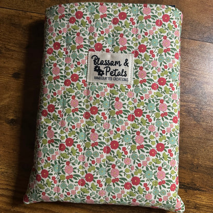 Handmade quilted floral book sleeve with padded cotton fabric for protecting books, journals, planners, and e-readers.