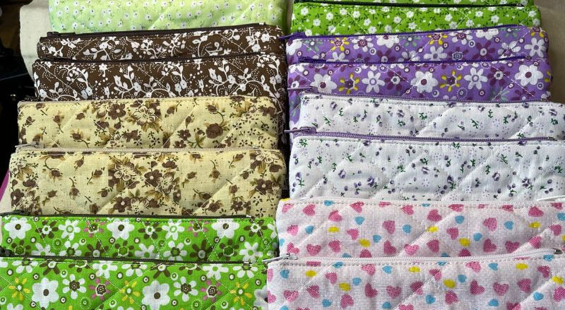 Collection of patterned fabric bags with visible brand labels on a flat surface.